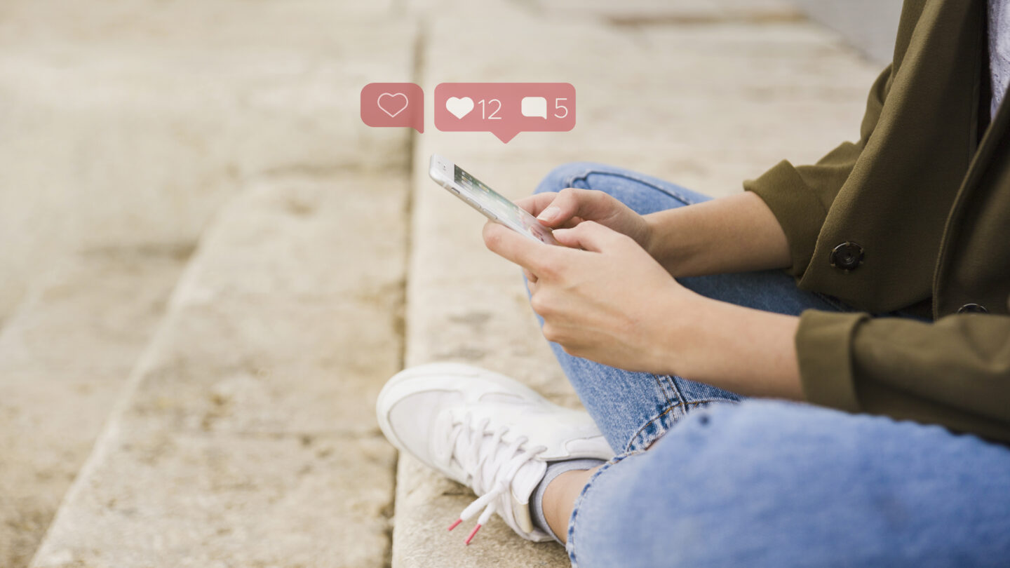 close-up-of-woman-sitting-on-stairs-using-social-media-app-on-mobile